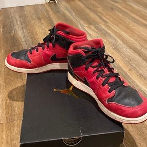 Youth red and black Nike Air Jordan high top sneakers